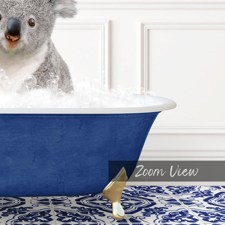 A koala sitting in a blue bathtub filled with bubbles, with a white wall and a patterned tile floor in the background.