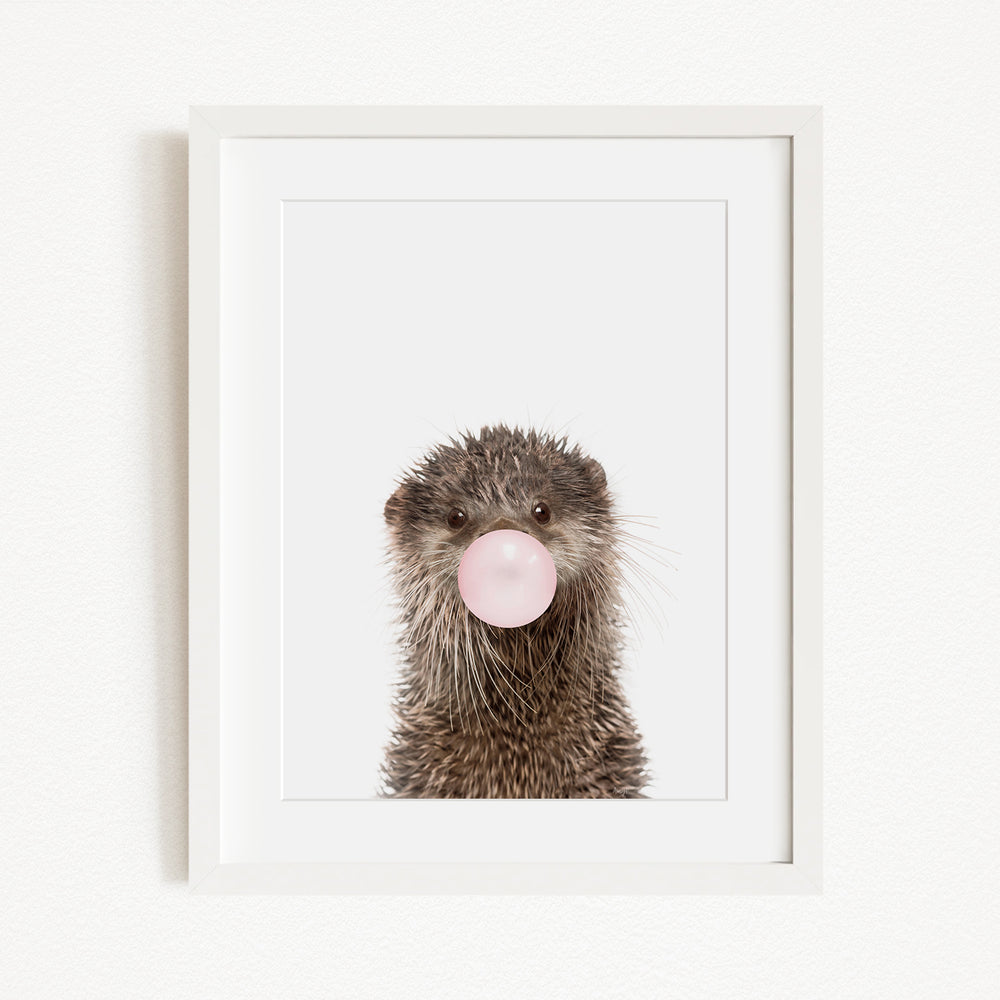 A picture of an otter blowing a bubble with a pink bubble gum bubble.