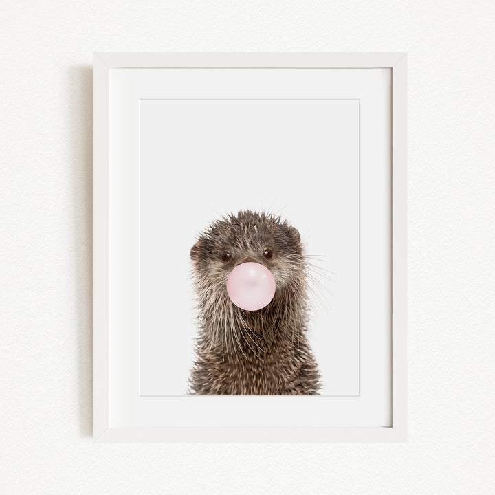 A picture of an otter blowing a bubble with a pink bubble gum bubble.