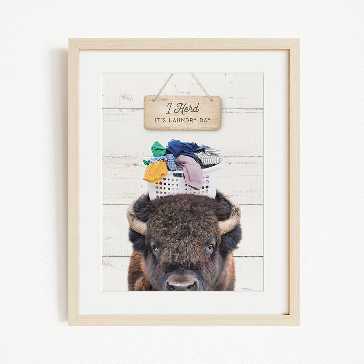 A framed image of a bison with a sign above it that says "I herd, it's laundry day".