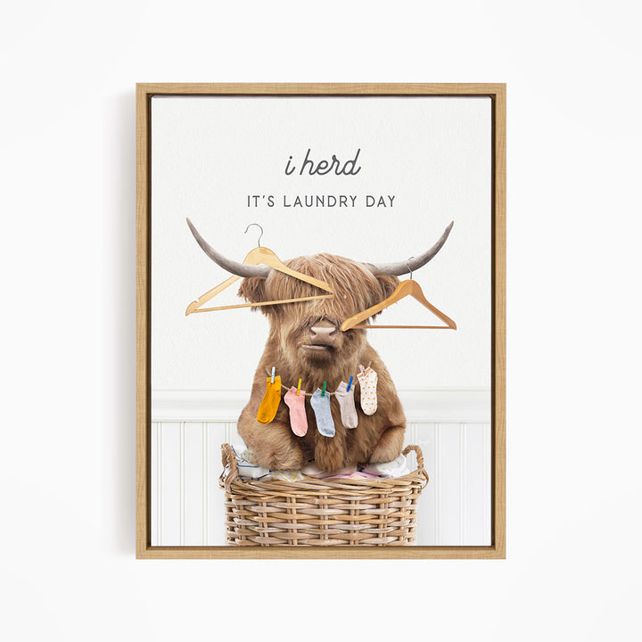 A brown cow with horns sits in a wicker basket, holding clothes on its horns and surrounded by clothes hanging on a clothesline.