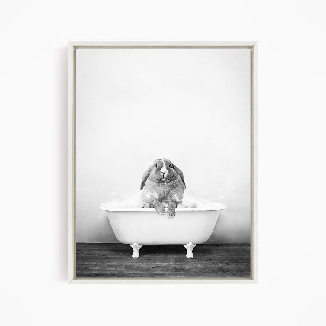 A rabbit sitting in a bathtub filled with water, appearing to be enjoying the bath.