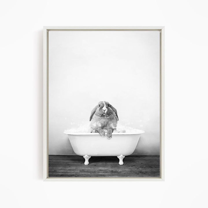 A rabbit sitting in a bathtub filled with water, appearing to be enjoying the bath.
