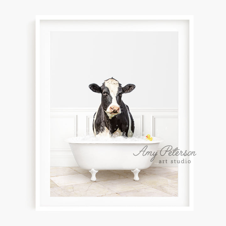 a black and white cow is sitting in a bathtub