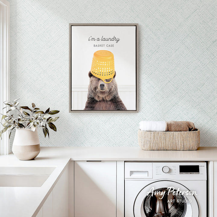 a bear wearing a yellow bucket hat and sunglasses, with a framed print of the bear above a basket on a white countertop.
