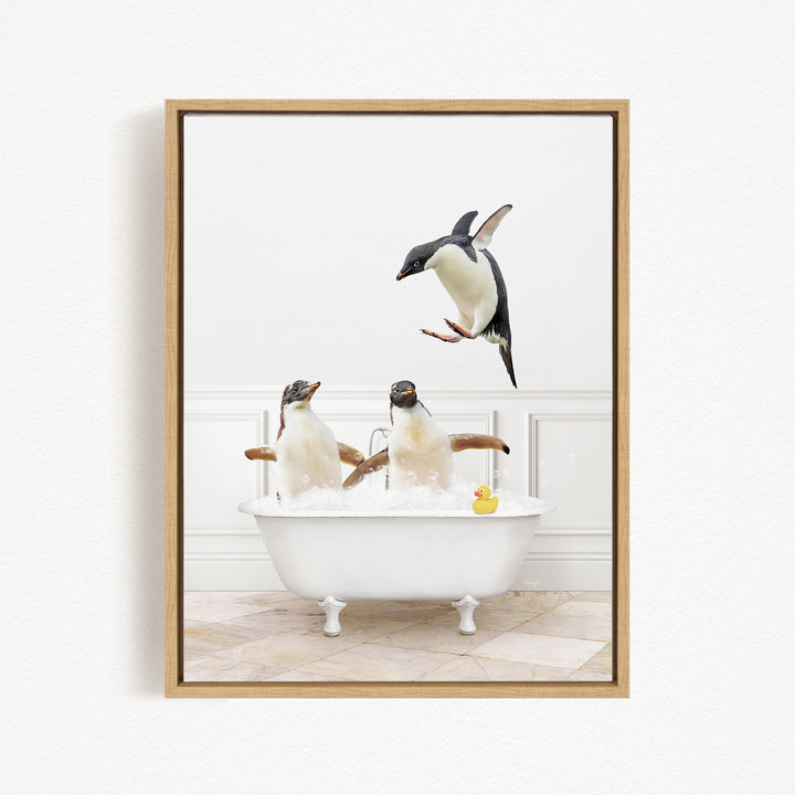 A framed image depicting two penguins sitting in a bathtub, with one penguin jumping out of the tub and another penguin sitting in the tub.