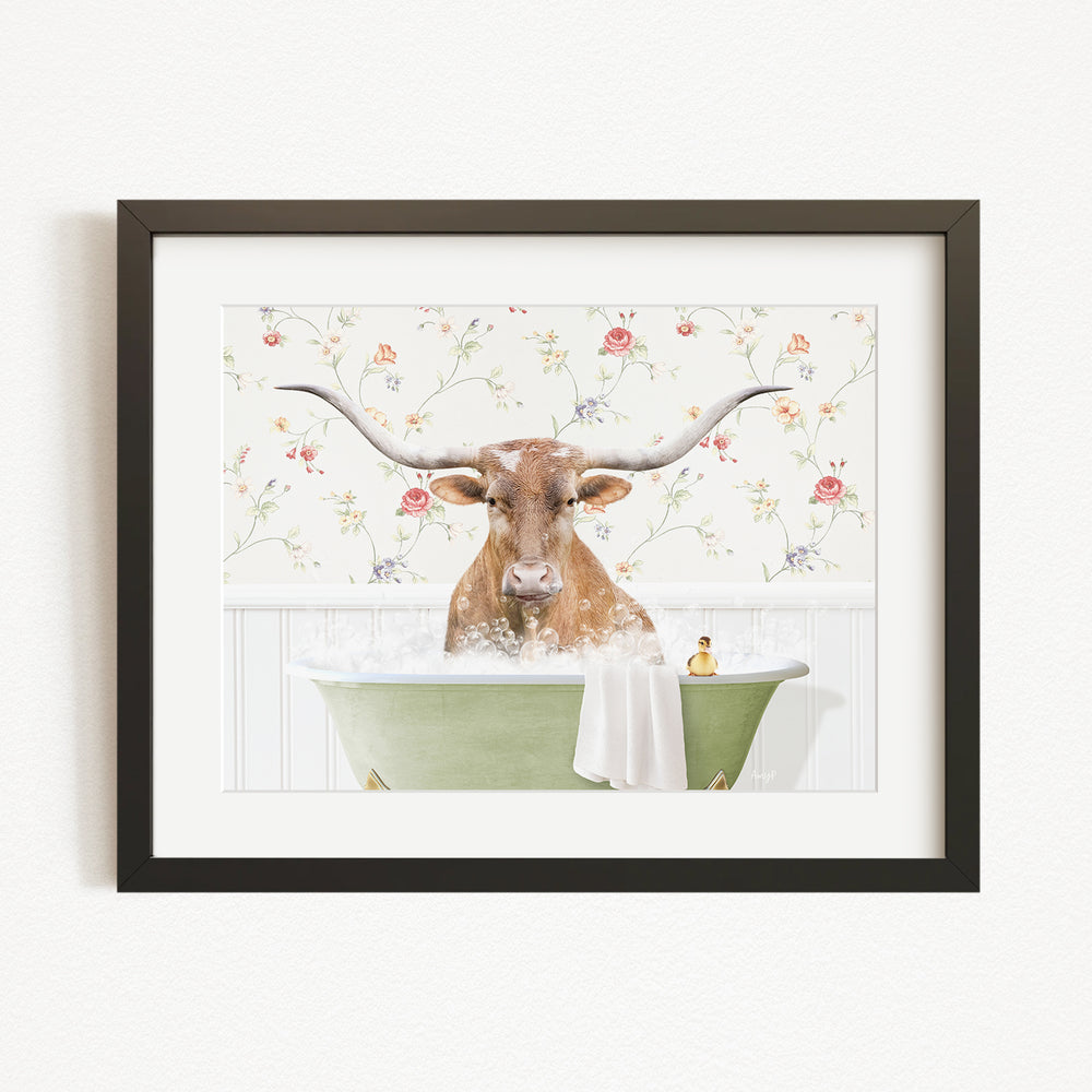 A brown cow with large horns is sitting in a green bathtub filled with water, surrounded by a floral patterned wall.