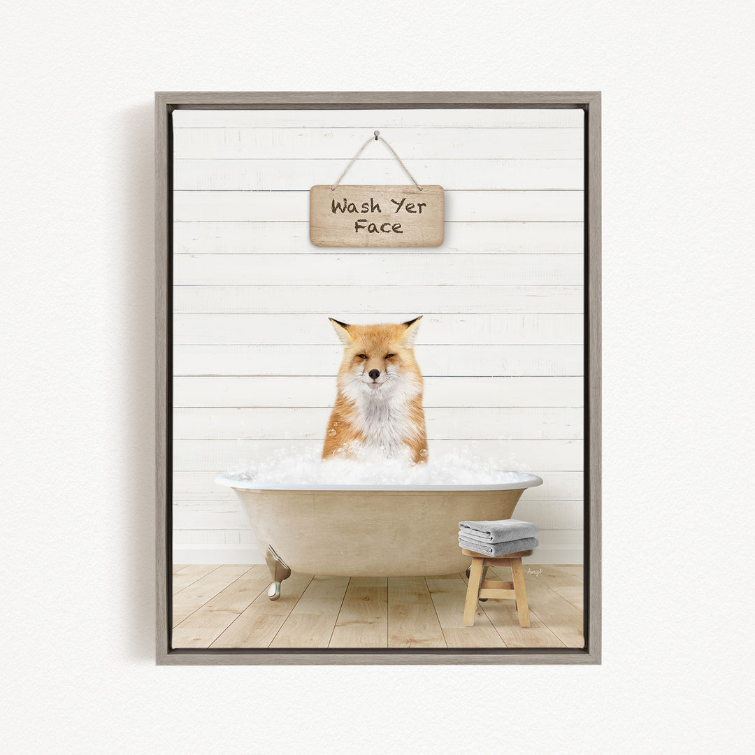 A framed image depicting a fox sitting in a bathtub filled with water, with a sign above that reads "Wash Yer Face".