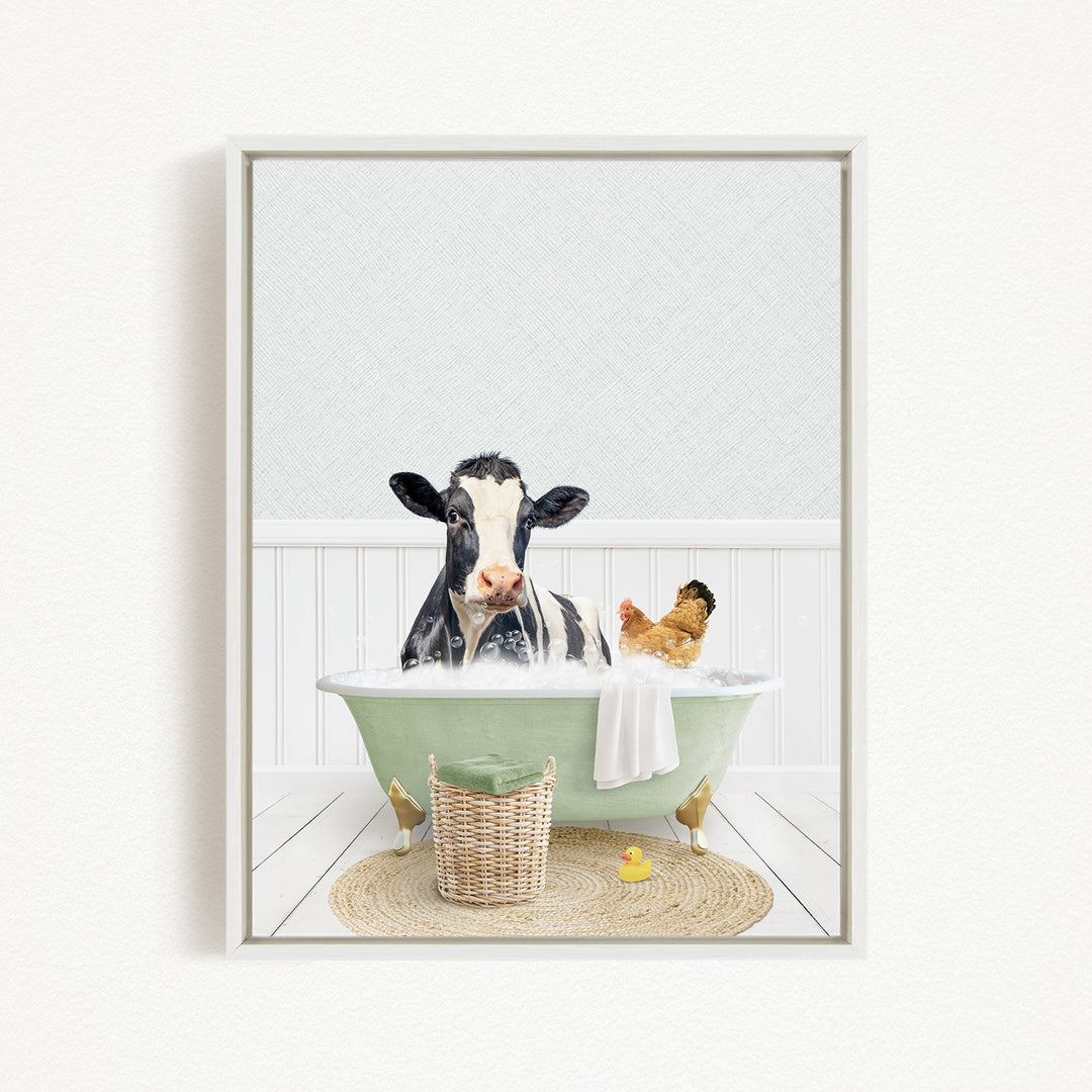 A black and white cow is sitting in a green bathtub, surrounded by a chicken and a duck, with a basket of bath toys nearby.
