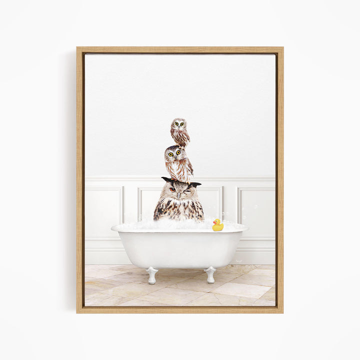 A framed image depicting three owls sitting on a white bathtub, with a rubber duck floating in the water.