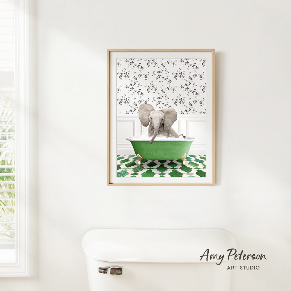 A framed image of an elephant sitting in a green bathtub, with a patterned wall behind it.