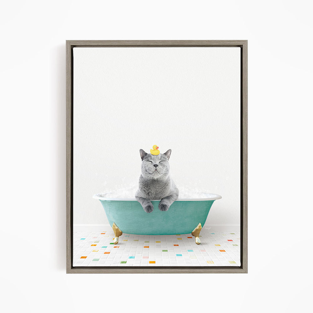 A gray cat sitting in a green bathtub, with a yellow rubber duck on its head, and a colorful tiled floor in the background.