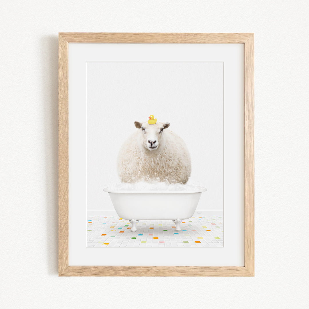 A white sheep with a yellow duck sitting in a white bathtub, surrounded by colorful tiles on the floor.