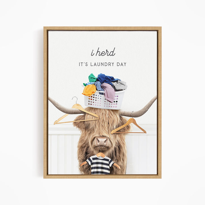 A framed image depicting a cow with a basket of laundry on its head, accompanied by the text "It's laundry day" and a humorous caption.