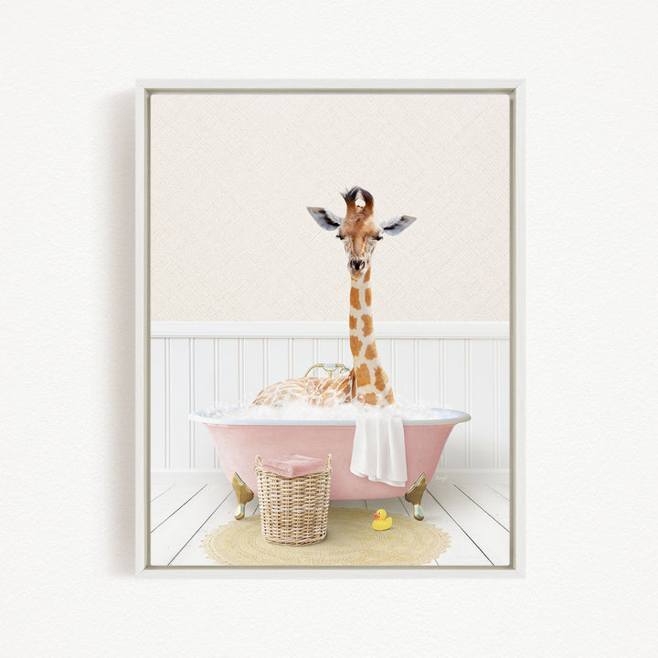 A giraffe is sitting in a pink bathtub filled with water, surrounded by a basket of rubber ducks and a towel.