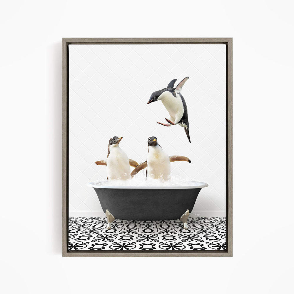 A framed image depicting two penguins standing in a bathtub filled with water, with one penguin jumping out of the tub.
