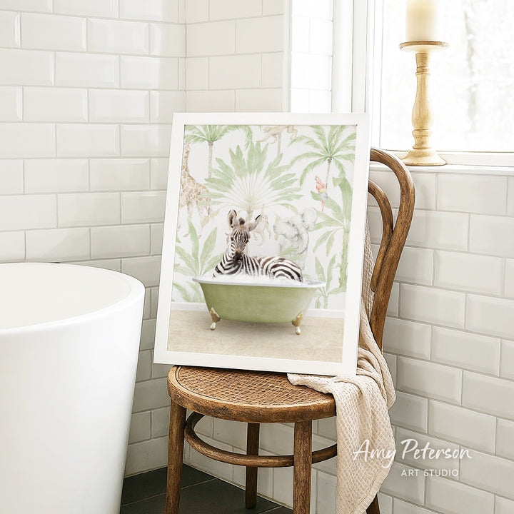 A framed print of a zebra sitting in a bathtub is displayed on a wooden chair in a bathroom setting.