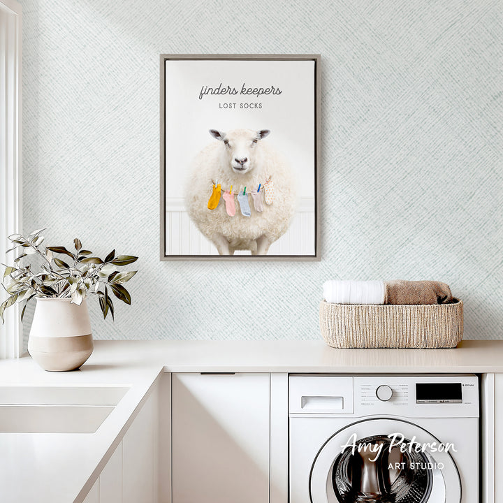 a white sheep wearing colorful clothes, hanging on a clothesline, and sitting on a shelf. The sheep is surrounded by various household items, including a basket of towels and a potted plant. The scene is set in a room with a white countertop and a washing machine.