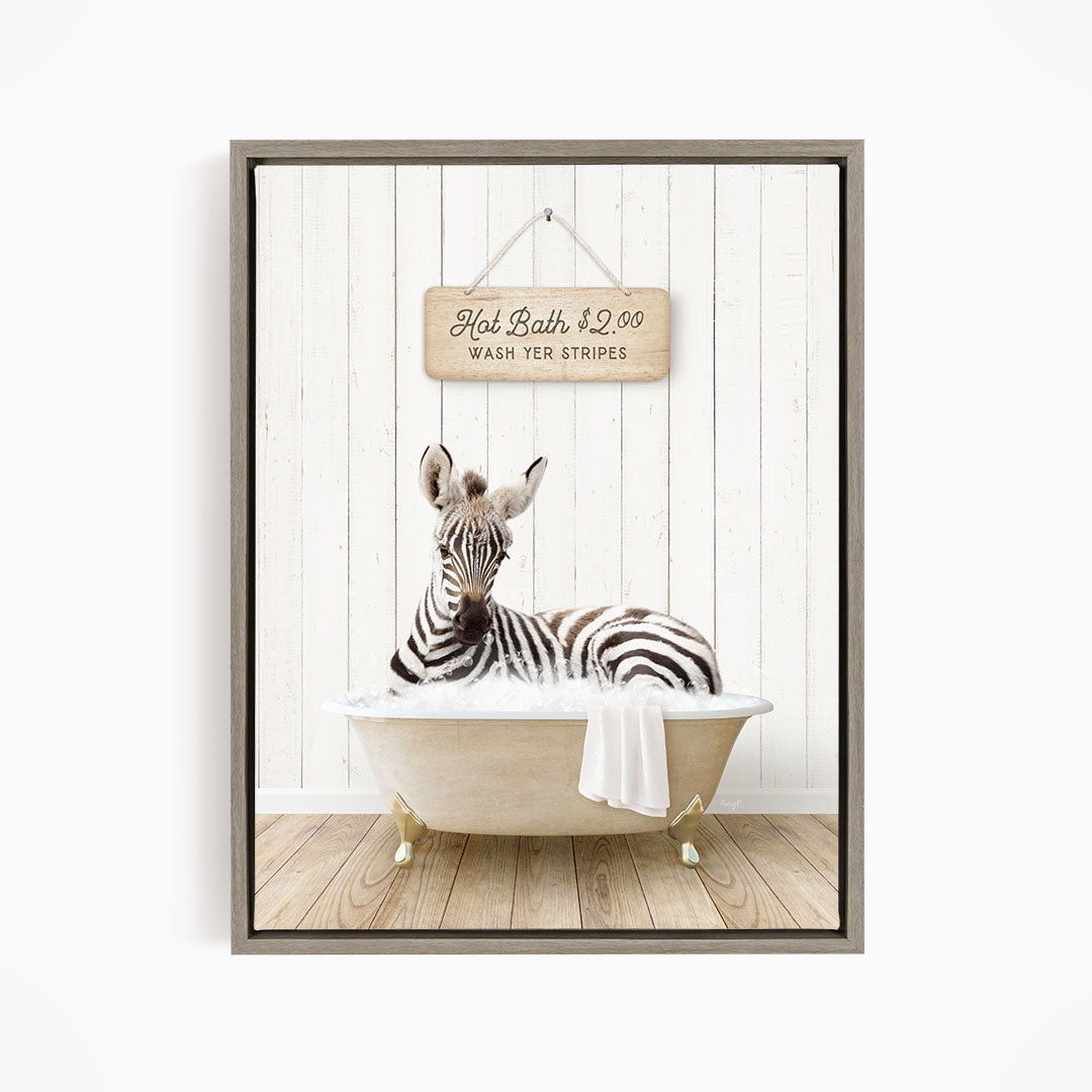 A zebra is sitting in a bathtub, with a wooden sign above it that reads "Hot Bath $2.00 WASH YER STRIPES".