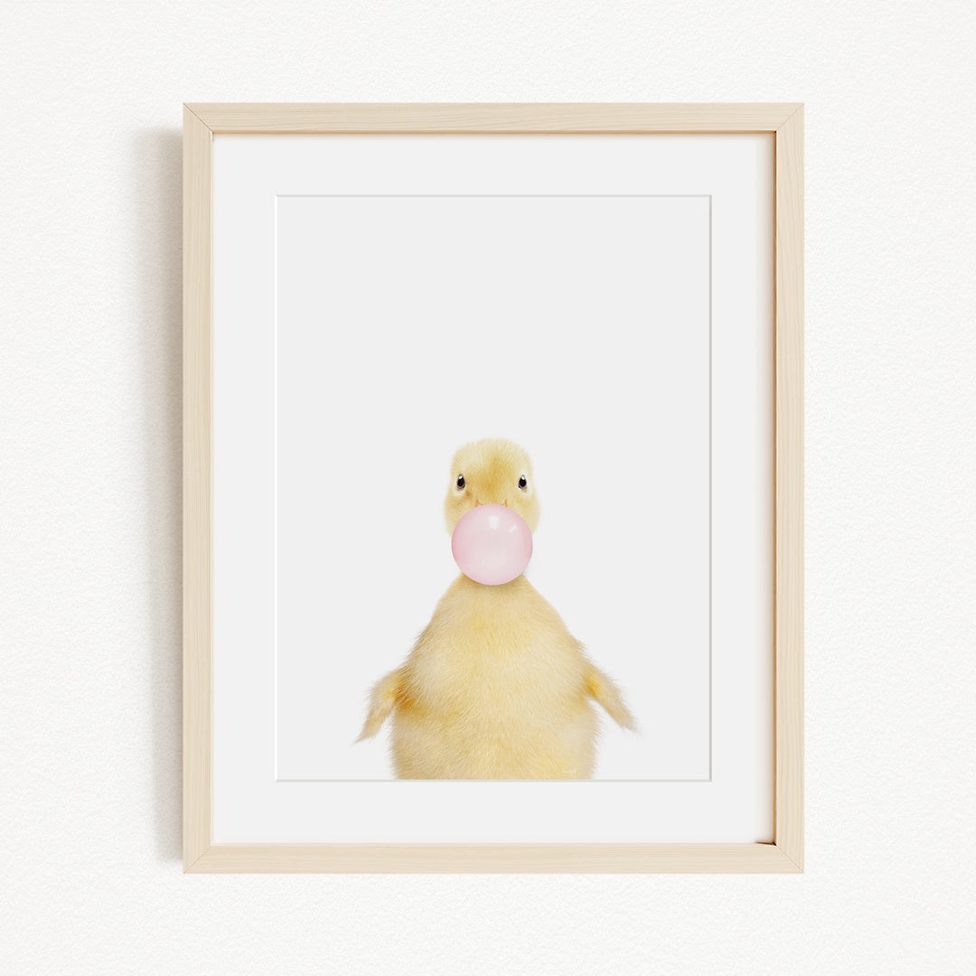 A cute yellow duck blowing a bubble with a pink bubble gum bubble.