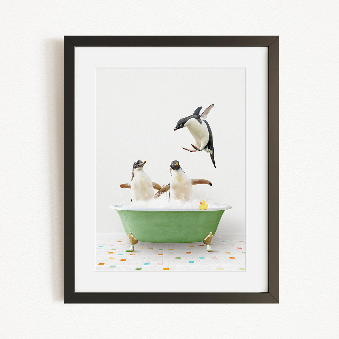 A framed image depicting two penguins sitting in a green bathtub, with one penguin jumping out of the tub.