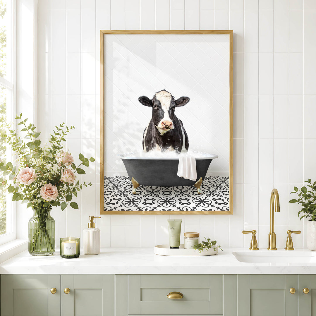 a bathroom with a framed picture of a cow sitting in a bathtub, surrounded by flowers and candles.