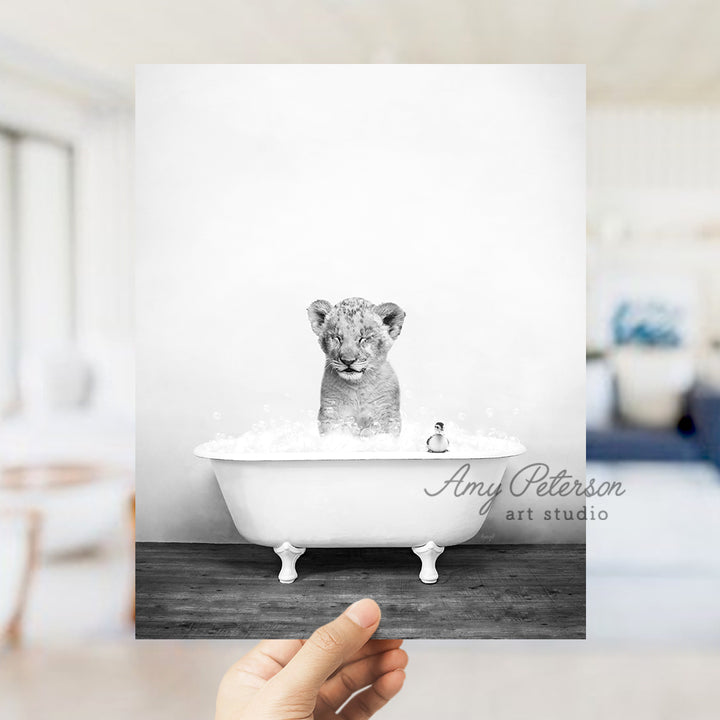 a person holding up a card with a picture of a baby tiger in a bath