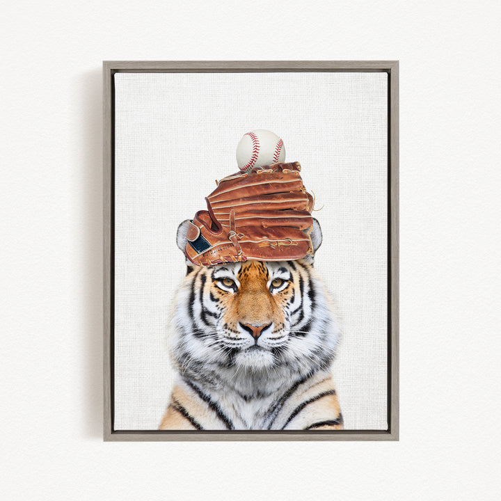 A tiger wearing a baseball cap and holding a baseball in its mouth.