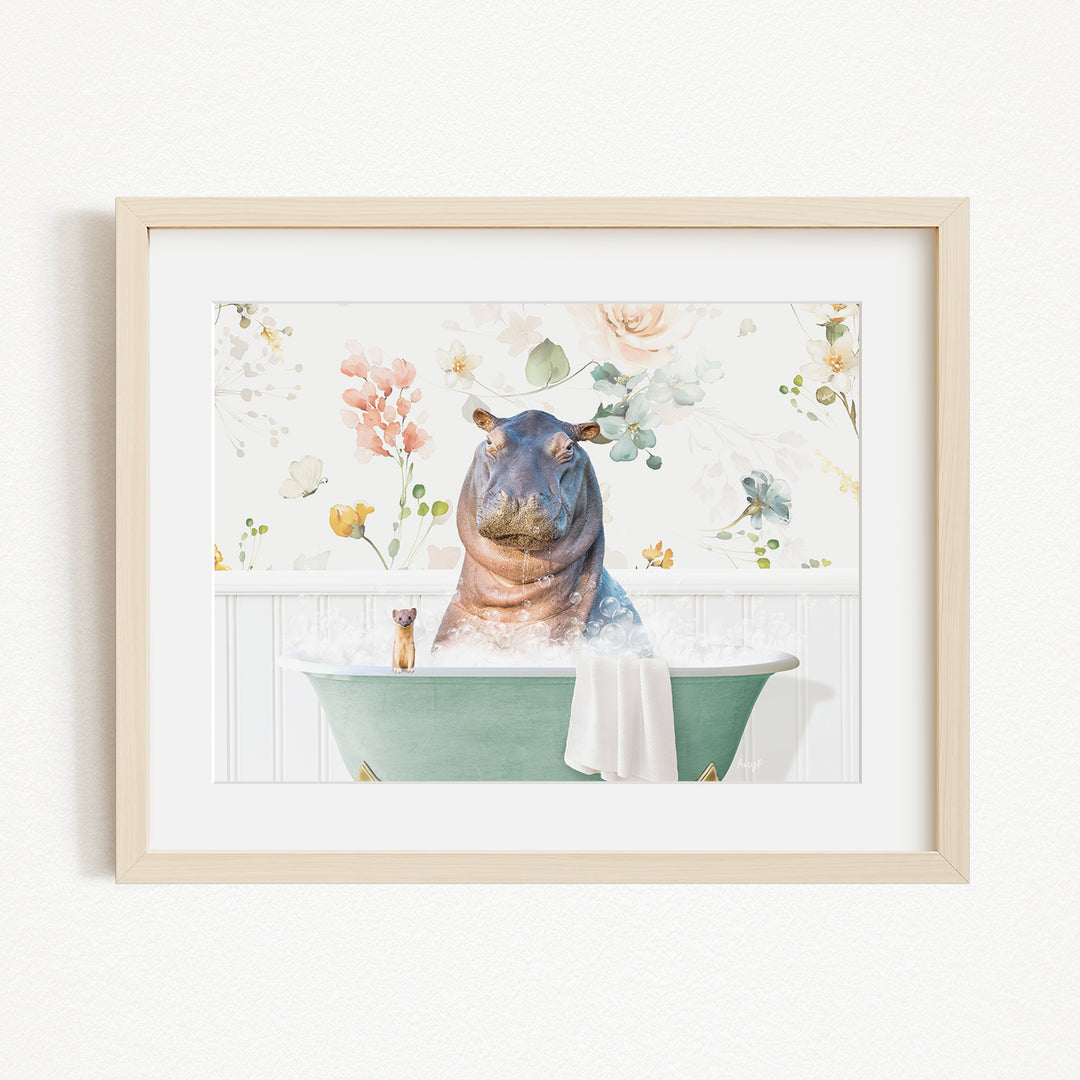 A framed image depicting a hippopotamus sitting in a green bathtub filled with water, surrounded by flowers and greenery.