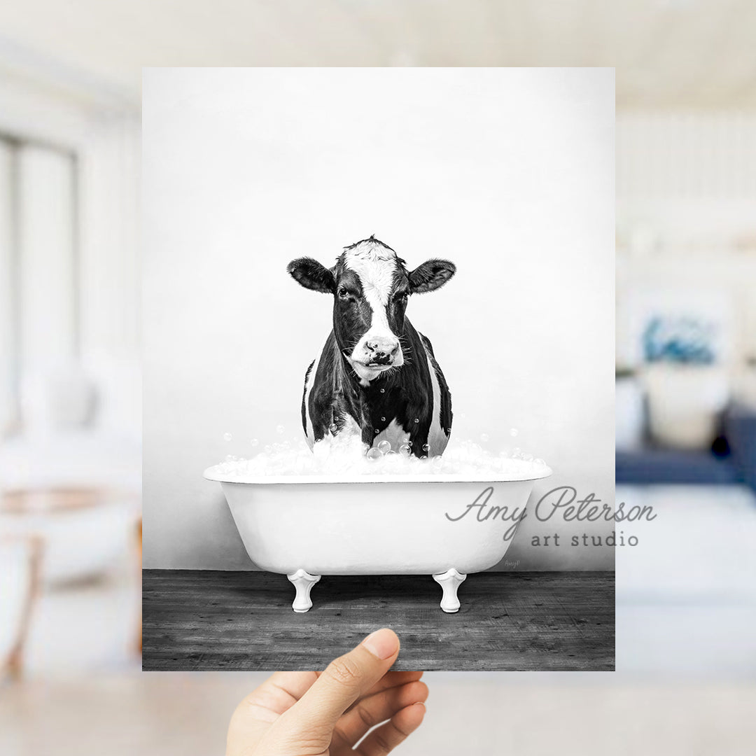 a black and white photo of a cow in a bathtub