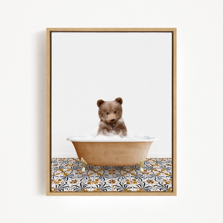 A cute brown bear cub sitting in a bathtub filled with bubbles, surrounded by a patterned tile floor.