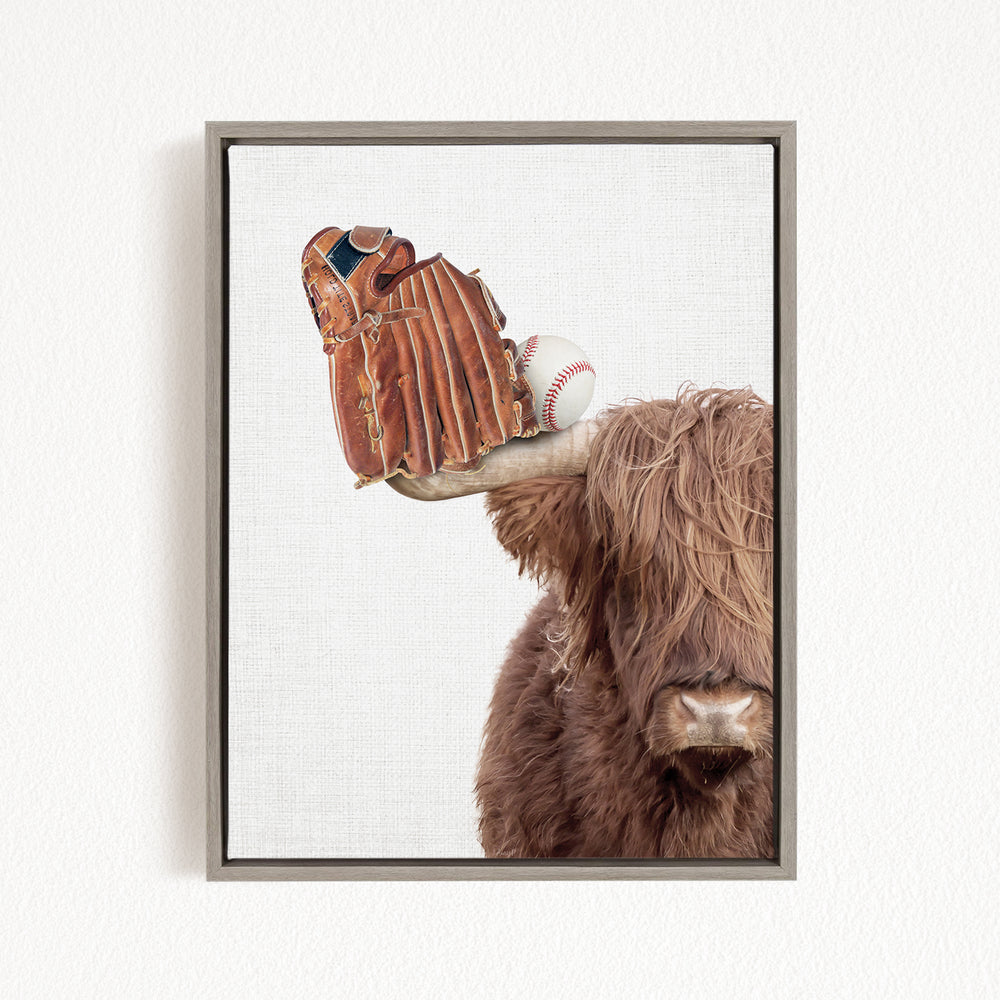 A framed image depicting a brown cow with a baseball glove on its head.