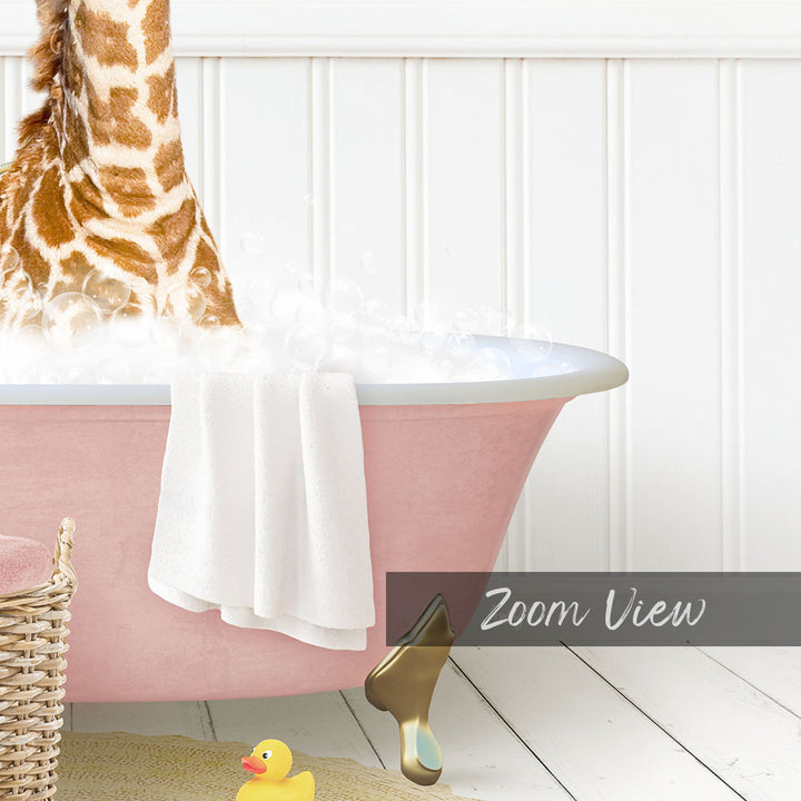 A giraffe standing in a pink bathtub filled with bubbles, with a towel and rubber duck nearby.
