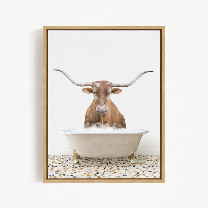A brown bull with long horns is sitting in a white bathtub filled with water, creating a playful and whimsical scene.