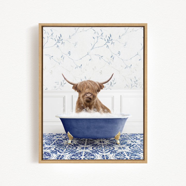 A brown cow with long horns is sitting in a blue bathtub filled with bubbles, surrounded by a blue and white patterned rug.