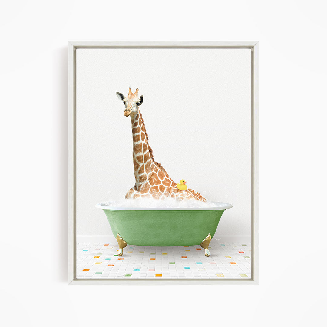 A giraffe is sitting in a green bathtub filled with bubbles, with a yellow rubber duck floating on the water.