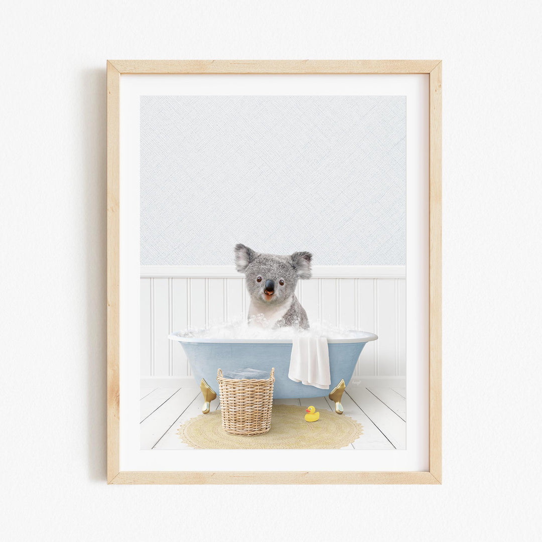 A koala bear sitting in a blue bathtub filled with water, surrounded by a yellow rubber duck and a wicker basket.