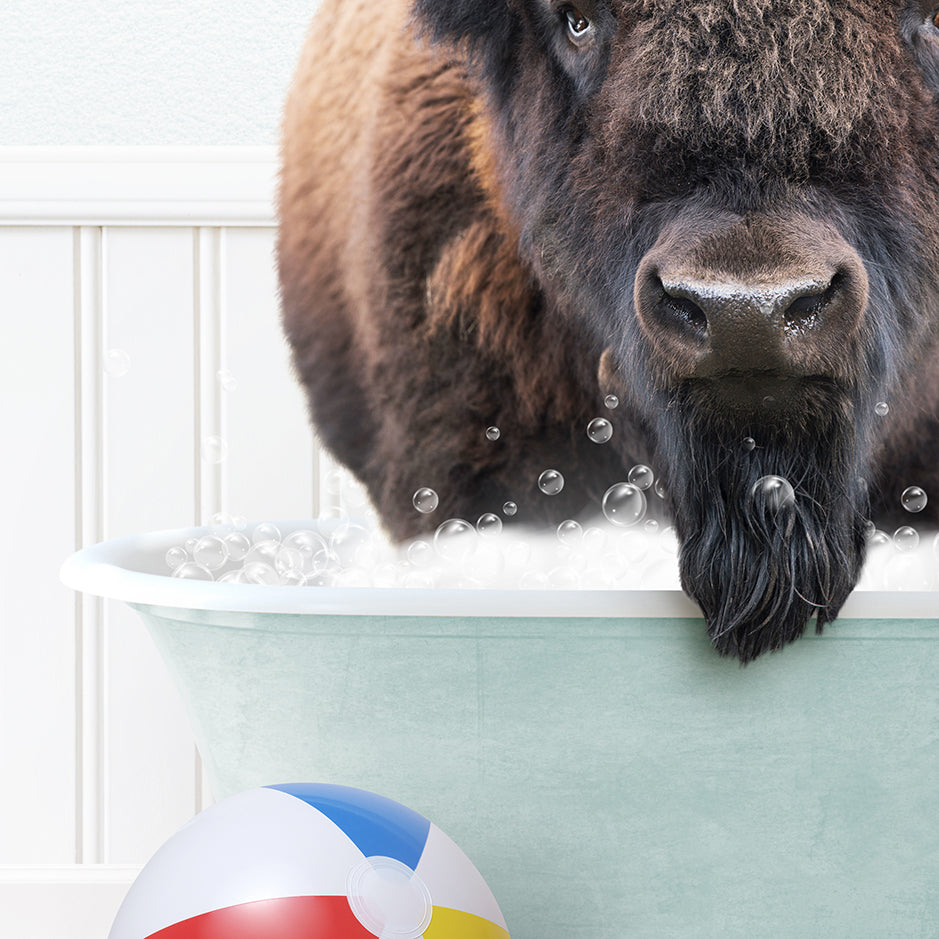 a large buffalo standing in a bathtub next to a beach ball