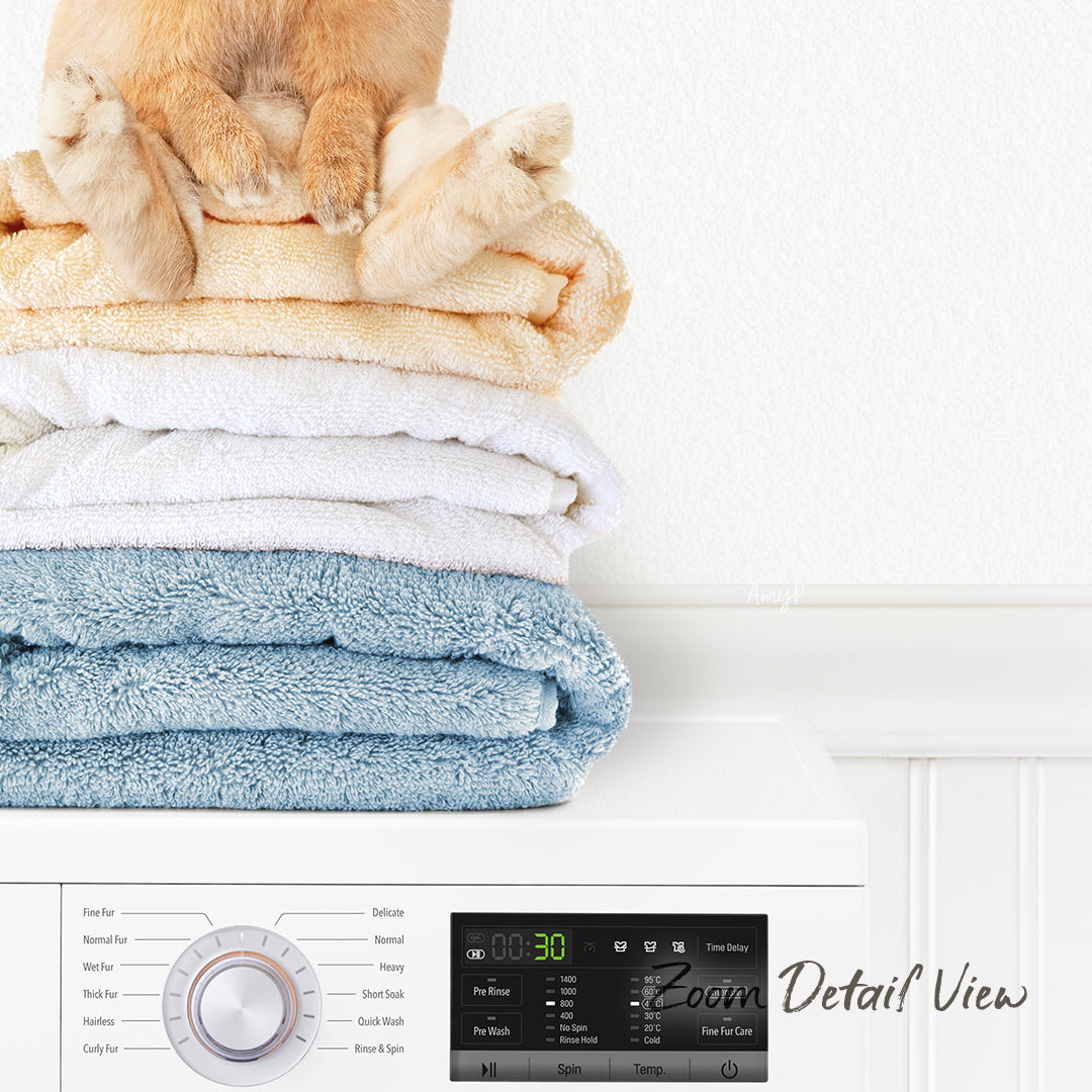 A stack of folded towels on top of a washing machine, with a cat sitting on top of the towels.