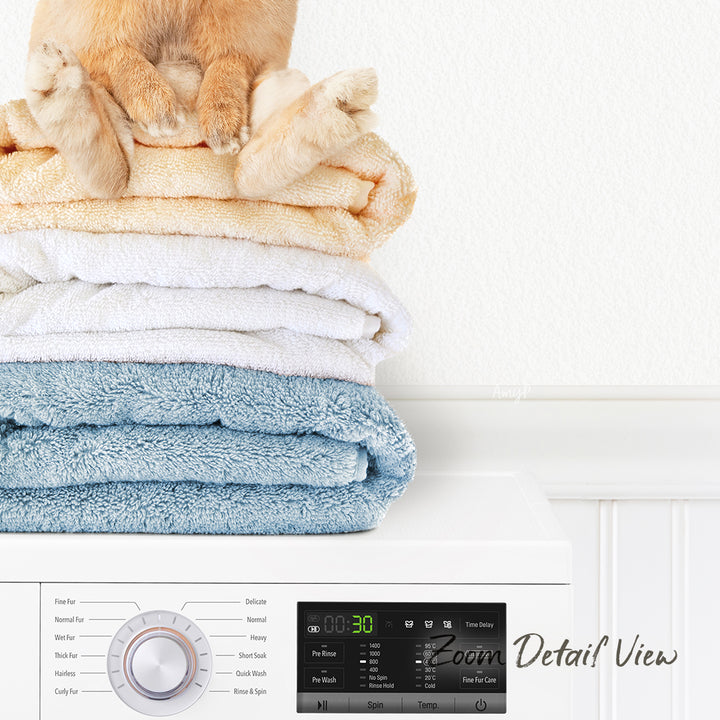 A stack of folded towels on top of a washing machine, with a cat sitting on top of the towels.