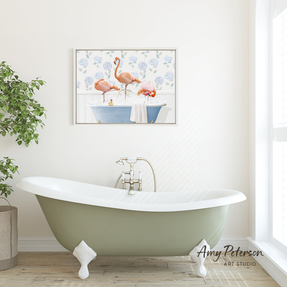 a bathroom with a green clawfoot bathtub, a framed painting of flamingos in a bathtub, and a potted plant on the side.