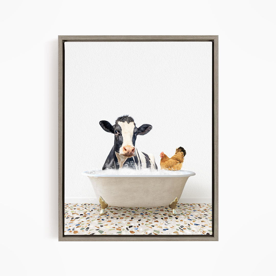 A black and white cow is sitting in a white bathtub, with a chicken standing nearby, both appearing to enjoy a relaxing bath together.