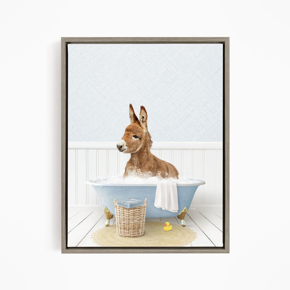 A donkey is sitting in a blue bathtub filled with water, surrounded by a basket of toys and a yellow rubber duck.