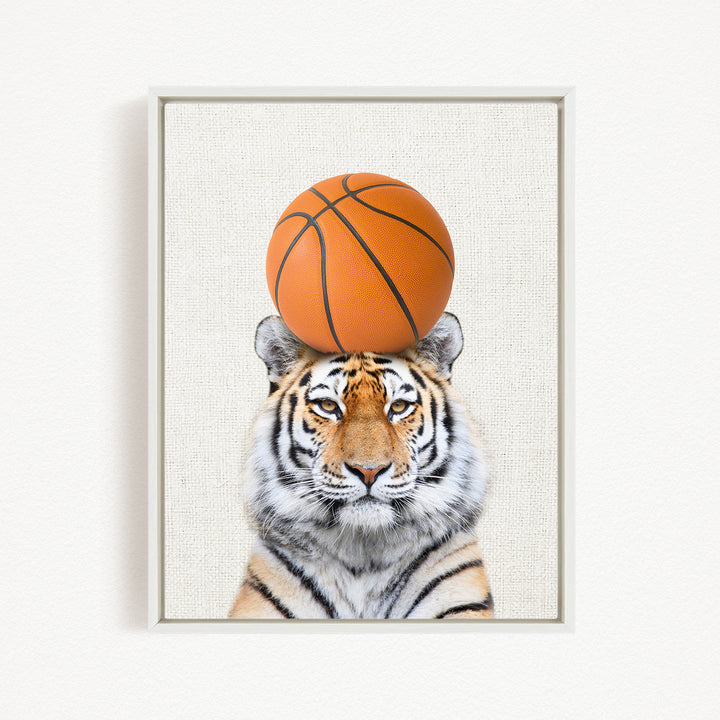 A tiger is sitting on a basketball, with the basketball positioned on its head.