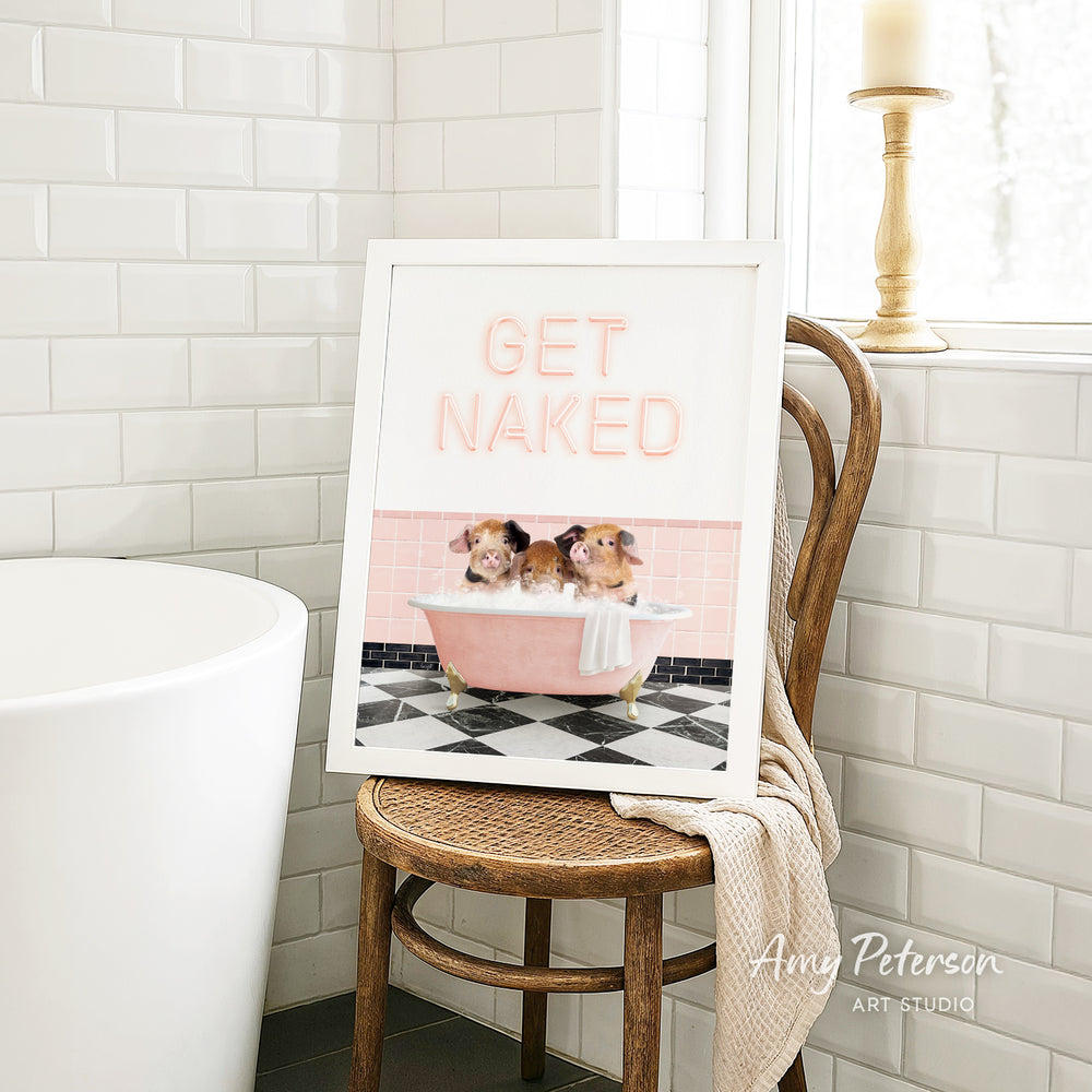 A framed print with a cartoon image of three hamsters sitting in a pink bathtub, with the text "GET NAKED" displayed on the frame.