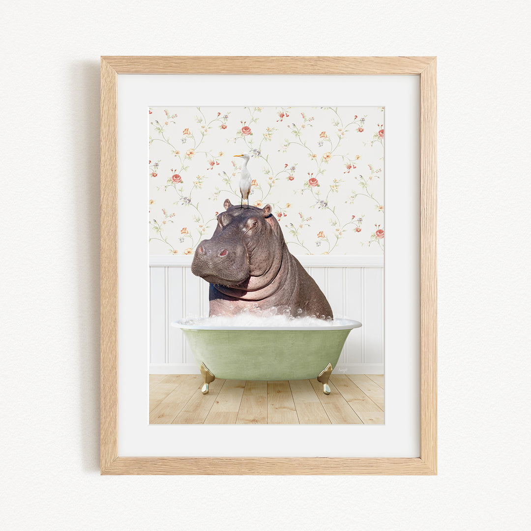 A framed image depicting a hippopotamus sitting in a bathtub filled with water, with a bird perched on its head.