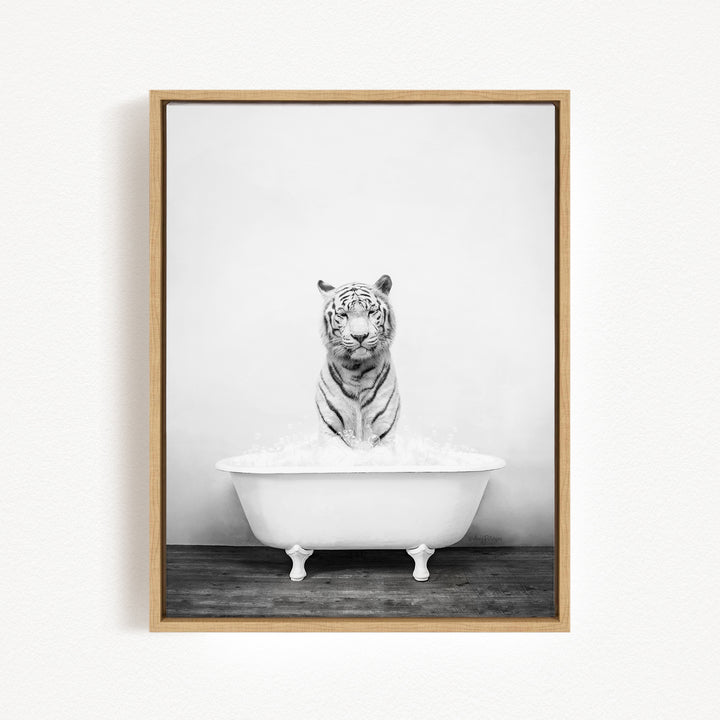 A black and white photograph of a tiger sitting in a white bathtub filled with water.