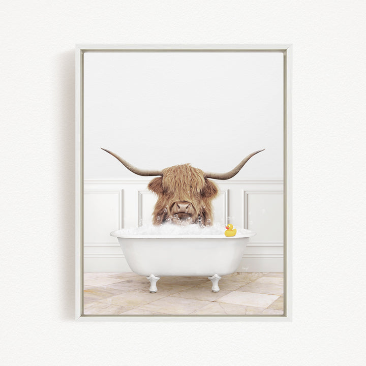 A Highland cow with long horns is sitting in a white bathtub, surrounded by bubbles, with a rubber duck floating nearby.