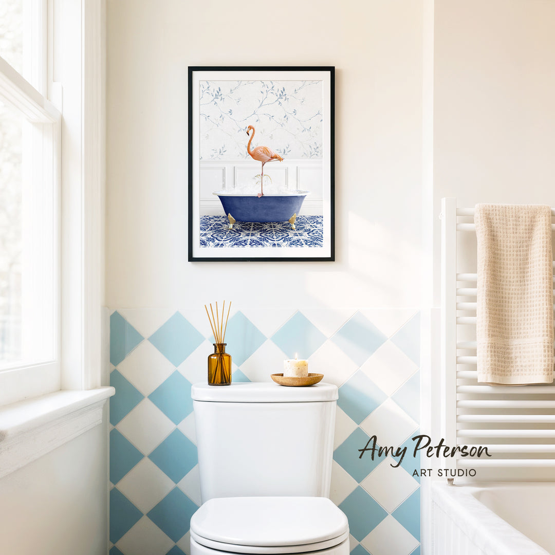 a bathroom with a framed painting of a flamingo in a bathtub hanging on the wall above a white toilet.