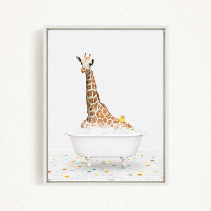 A giraffe is sitting in a white bathtub filled with bubbles, with a yellow duck sitting on its back.